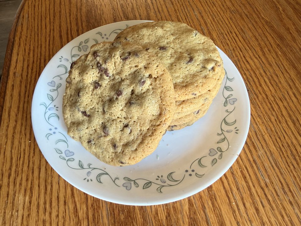 Chocolate chip cookies stacked on a patterned plate
