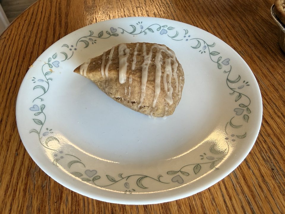 An iced pumpkin scone on a patterned plate