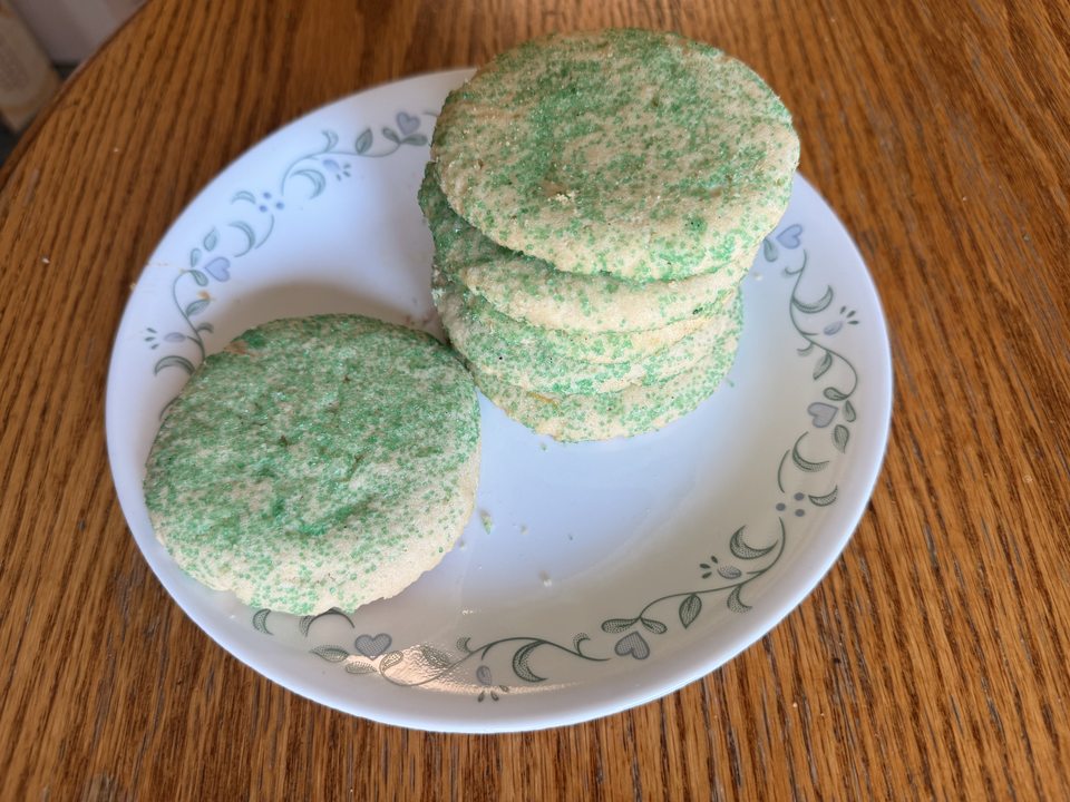 Green sugar-coated cookies stacked on a plate